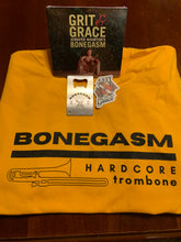 Load image into Gallery viewer, One golden yellow Bonegasm t-shirt that reads &quot;Bonegasm, Hardcore Trombone,&quot; one Grit &amp; Grace CD, one Grit &amp; Grace sticker and one Bonegasm bottle opener

